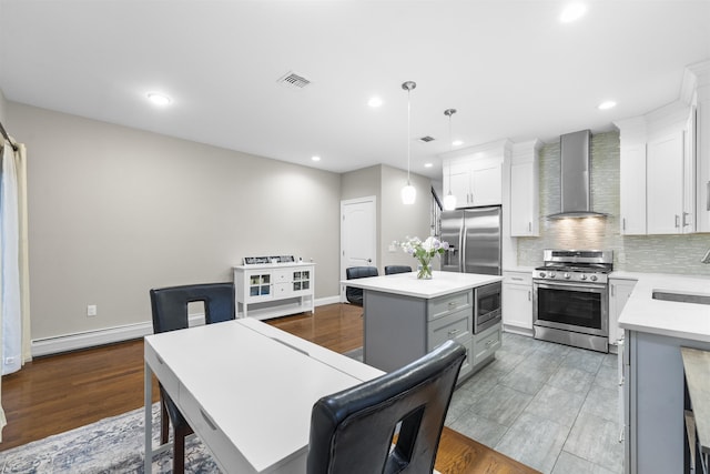 405 Commercial Ave, Cliffside Park, NJ 07010 - kitchen featuring appliances with stainless steel finishes, wall chimney exhaust hood, a baseboard heating unit, a center island, and light countertops