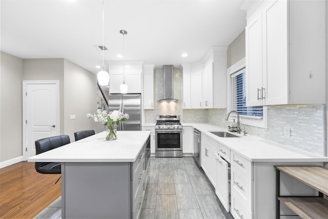 405 Commercial Ave, Cliffside Park, NJ 07010 - kitchen with wall chimney range hood, appliances with stainless steel finishes, a breakfast bar, decorative backsplash, and light countertops