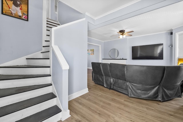 stairway featuring ornamental molding, wood finished floors, a ceiling fan, and baseboards