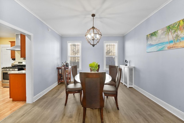 dining room featuring a chandelier, light wood finished floors, and baseboards