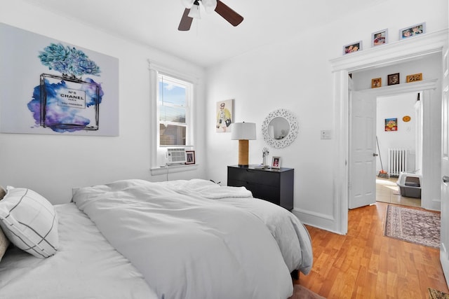 bedroom with ceiling fan, light wood finished floors, cooling unit, and baseboards