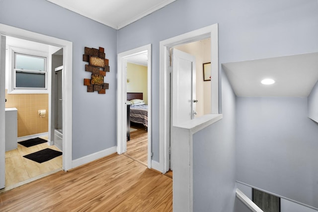 corridor featuring light wood-style floors and baseboards