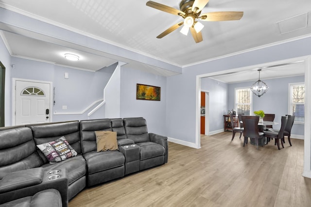 living room featuring ornamental molding, light wood-type flooring, and baseboards