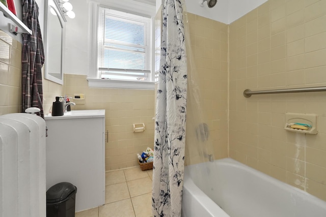 bathroom featuring tile walls, shower / bath combination with curtain, radiator heating unit, vanity, and tile patterned flooring