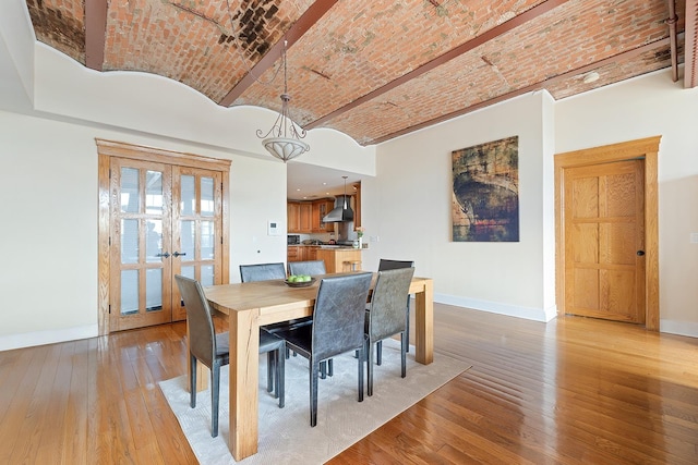 174 Washington St Unit 2K, Jersey City, NJ 07302 - dining space featuring baseboards, brick ceiling, wood-type flooring, and french doors