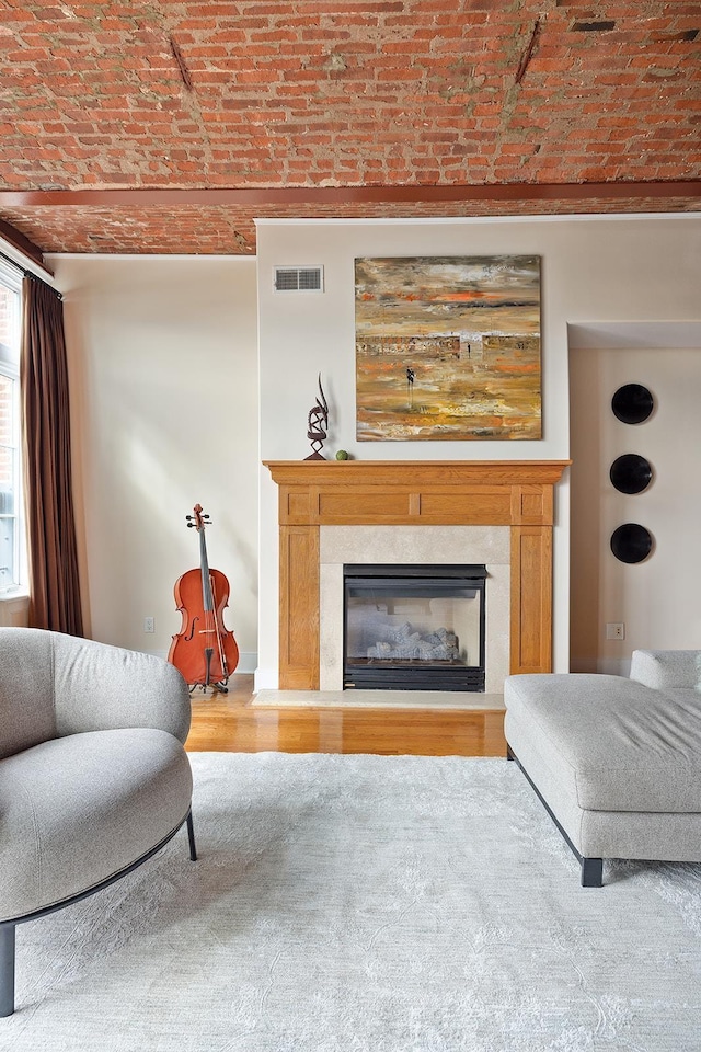174 Washington St Unit 2K, Jersey City, NJ 07302 - living area featuring brick ceiling, a fireplace, and wood finished floors