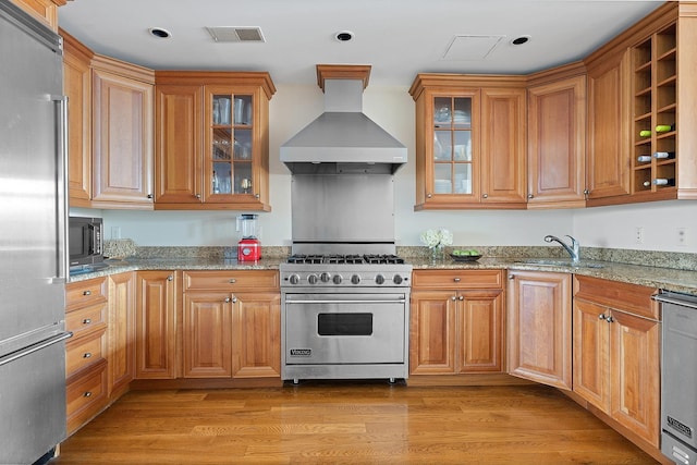 174 Washington St Unit 2K, Jersey City, NJ 07302 - kitchen featuring premium appliances, exhaust hood, a sink, light stone countertops, and glass insert cabinets