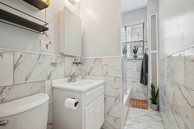 527 34th St Unit D1, Union City, NJ 07087 - full bath featuring vanity, toilet, marble look tile flooring, tile walls, and a wainscoted wall