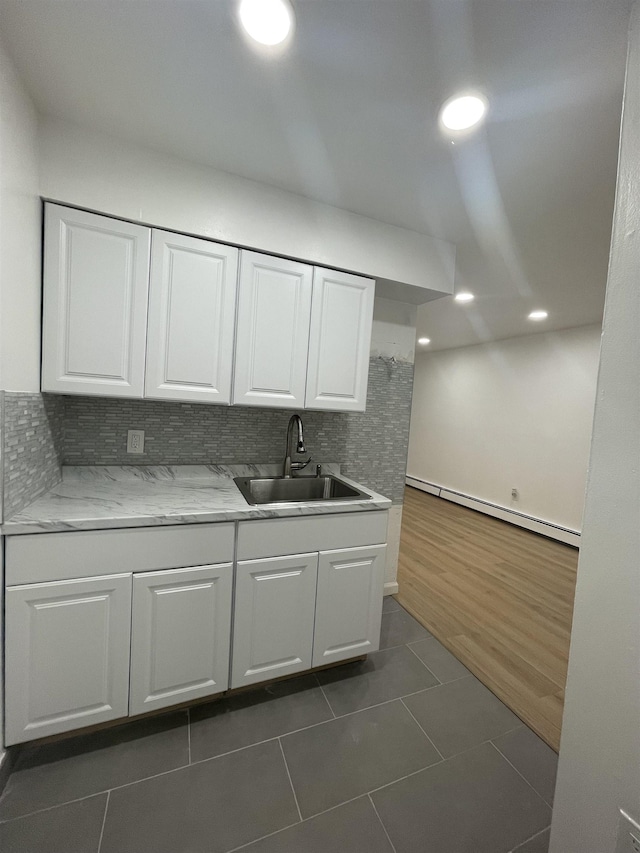 2200 Paterson Plank Rd Unit 25, North Bergen, NJ 07047 - kitchen featuring baseboard heating, white cabinets, dark tile patterned floors, tasteful backsplash, and recessed lighting
