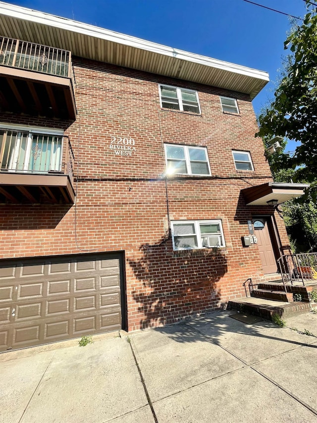 2200 Paterson Plank Rd Unit 25, North Bergen, NJ 07047 - rear view of property with brick siding, a garage, and driveway