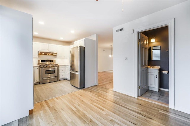 kitchen with appliances with stainless steel finishes, light hardwood / wood-style flooring, and white cabinetry