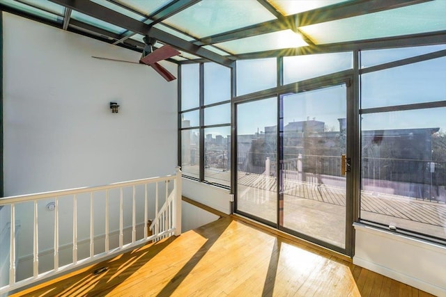 unfurnished sunroom featuring ceiling fan