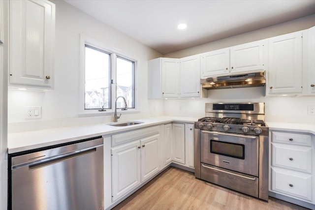 kitchen featuring appliances with stainless steel finishes, light wood-type flooring, white cabinets, and sink