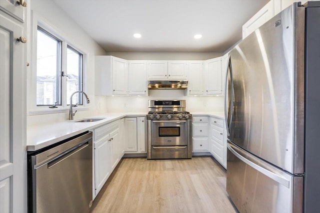 kitchen featuring sink, stainless steel appliances, white cabinetry, and light hardwood / wood-style floors