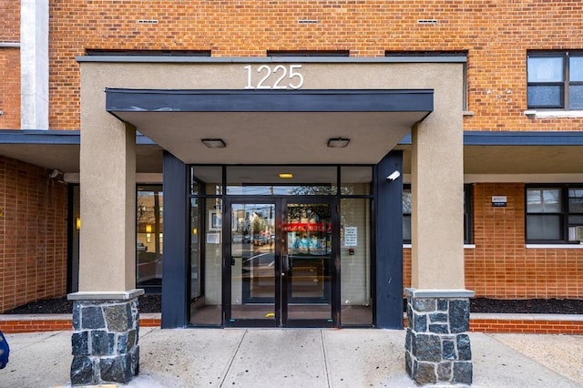 entrance to property featuring brick siding