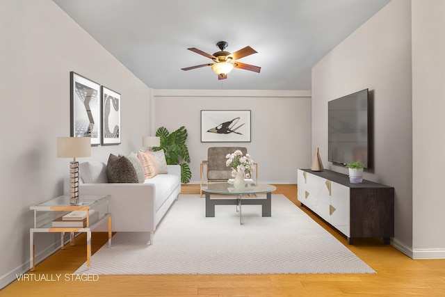 living room featuring baseboards, a ceiling fan, and wood finished floors
