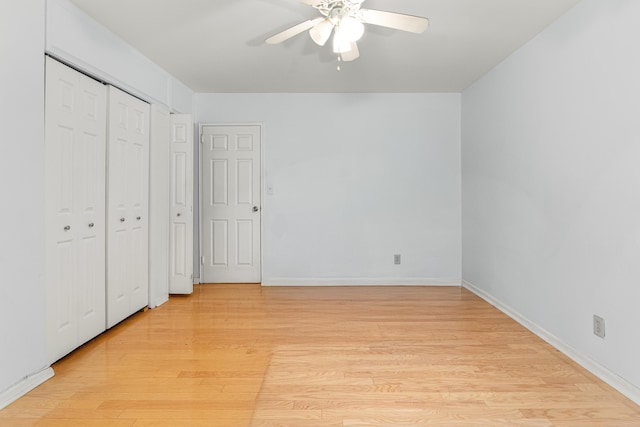 unfurnished bedroom featuring a closet, baseboards, a ceiling fan, and light wood-style floors