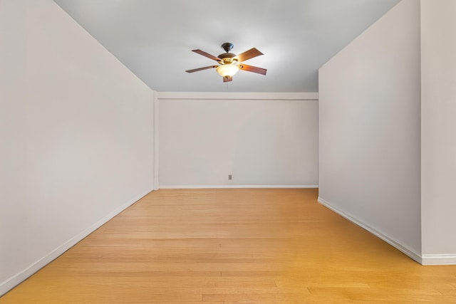 empty room with baseboards, ceiling fan, and wood finished floors