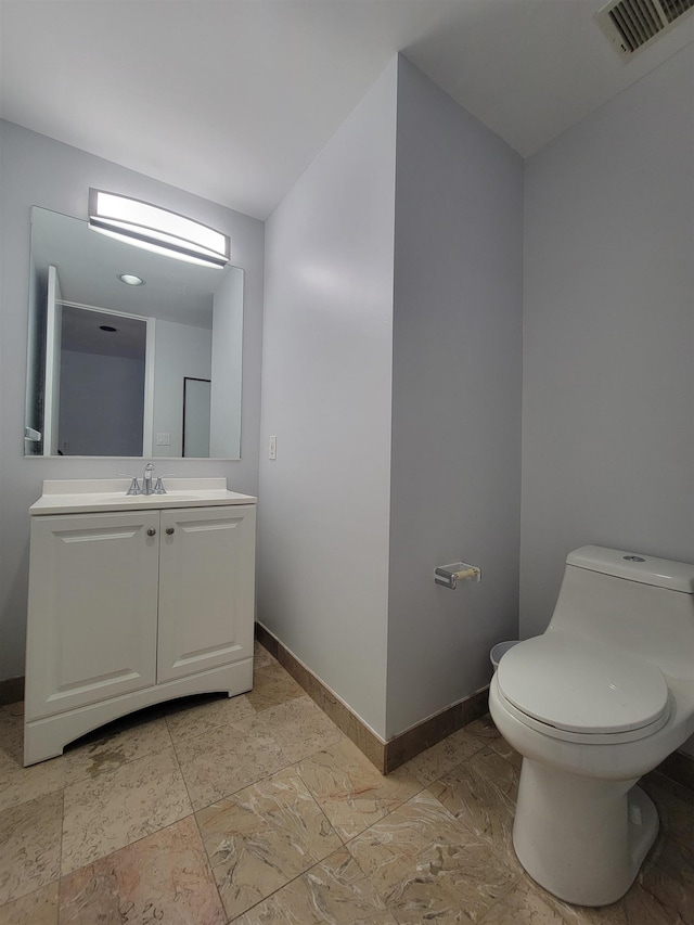 bathroom featuring baseboards, visible vents, vanity, and toilet