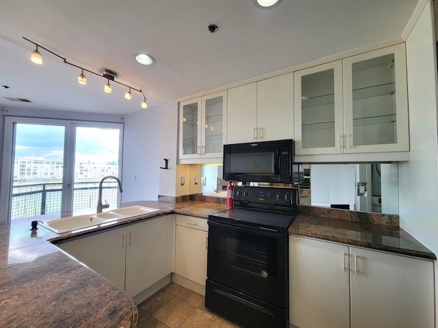 kitchen with a sink, visible vents, white cabinets, black appliances, and glass insert cabinets