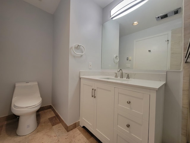 bathroom featuring vanity, toilet, and baseboards