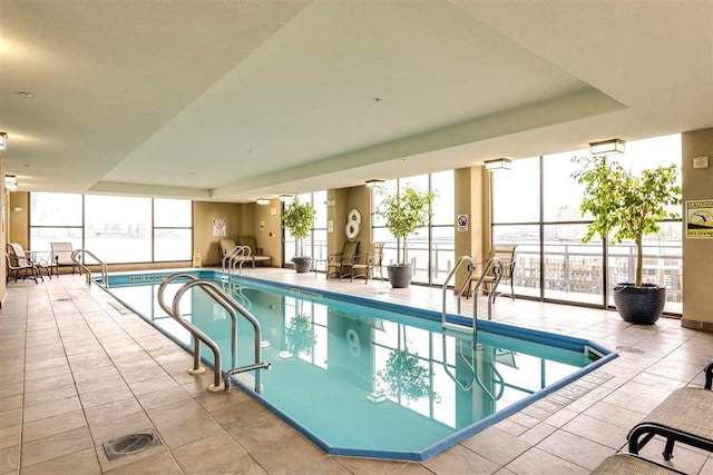 community pool featuring glass enclosure and a patio area