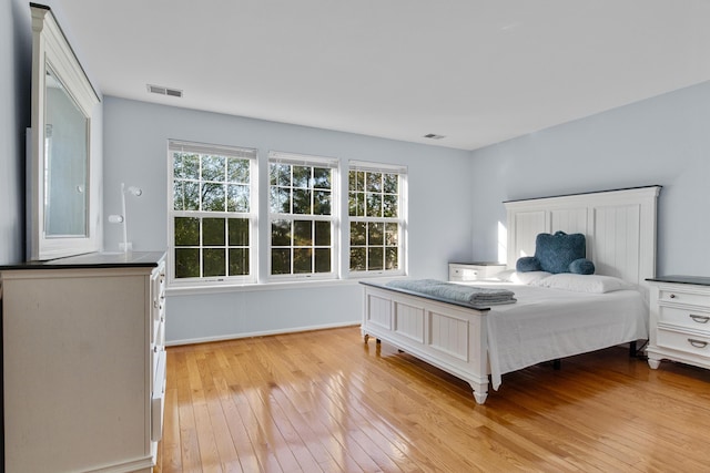 bedroom with visible vents, light wood-style flooring, and multiple windows