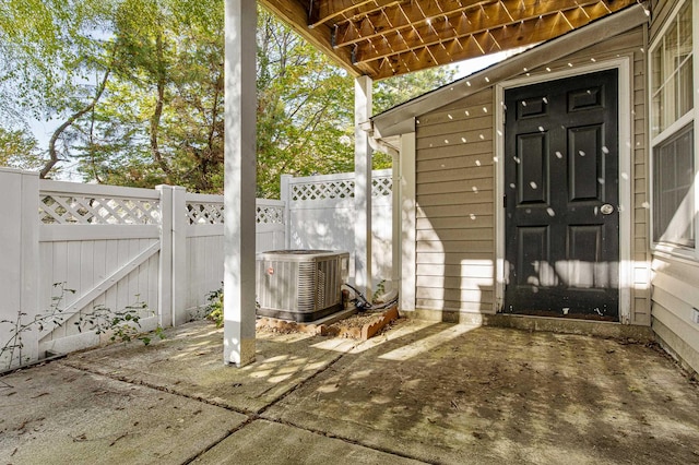 exterior space with central AC unit, fence, and a gate