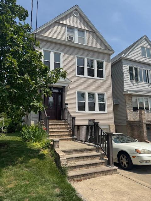 57 W 5th St, Bayonne, NJ 07002 - view of front of home with entry steps and a front lawn