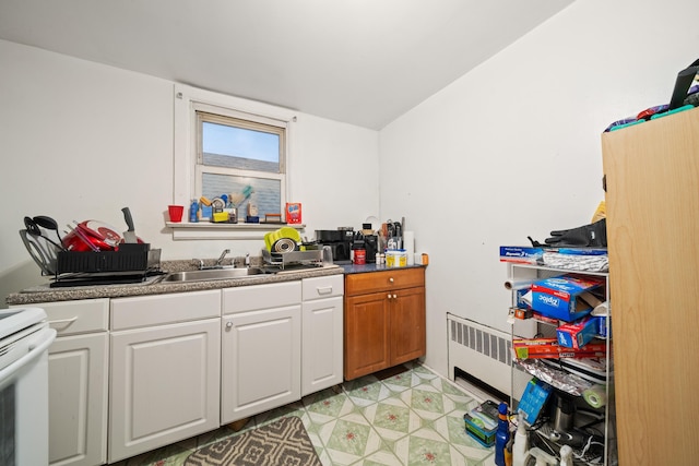 57 W 5th St, Bayonne, NJ 07002 - kitchen with radiator, white cabinetry, a sink, and white range