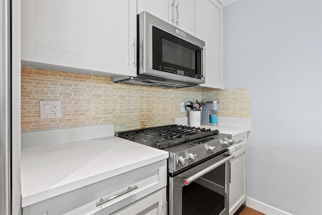 kitchen with stainless steel appliances, tasteful backsplash, light countertops, and white cabinetry