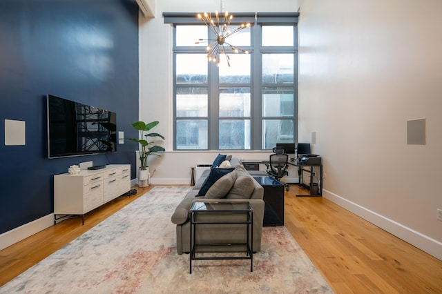 living area featuring light wood-type flooring, radiator heating unit, and a notable chandelier