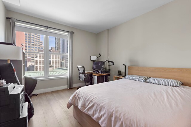 bedroom with wood finished floors and baseboards