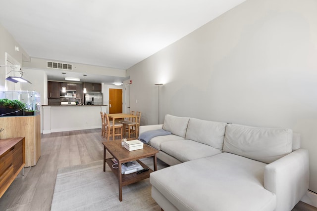 living area with light wood-type flooring and visible vents