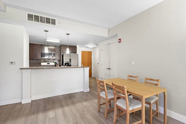 dining room with visible vents, baseboards, and wood finished floors