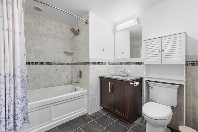 bathroom with toilet, vanity, tile walls, tile patterned floors, and shower / bath combo