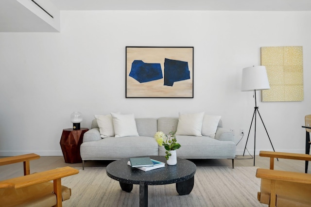 living area with baseboards and wood finished floors