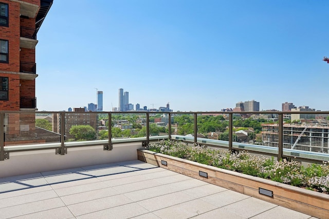 view of patio / terrace featuring a view of skyline and a balcony