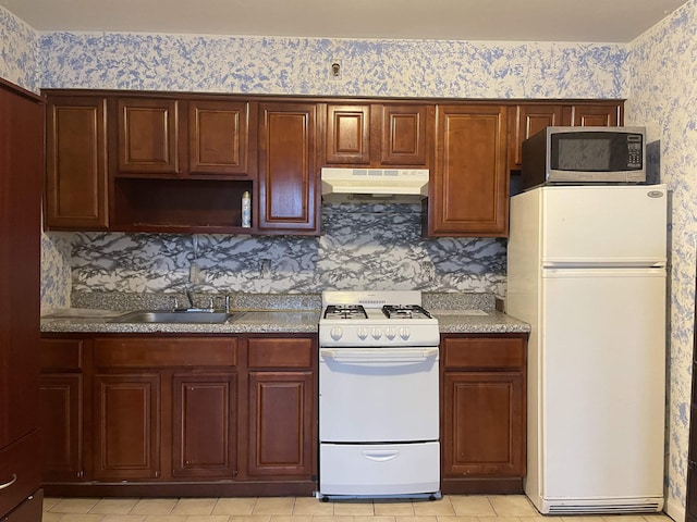 502 Central Ave Unit D1, Jersey City, NJ 07307 - kitchen featuring white appliances, under cabinet range hood, wallpapered walls, light tile patterned floors, and light countertops