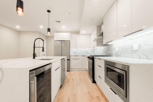 211 Summit Ave Unit 2, Jersey City, NJ 07304 - kitchen featuring modern cabinets, appliances with stainless steel finishes, beverage cooler, white cabinetry, and light wood-style floors