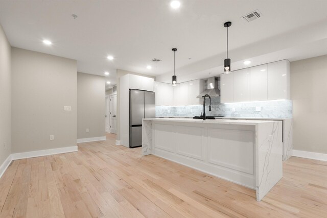 211 Summit Ave Unit 2, Jersey City, NJ 07304 - kitchen featuring freestanding refrigerator, wall chimney range hood, white cabinetry, tasteful backsplash, and recessed lighting