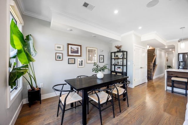 dining space featuring dark hardwood / wood-style floors and crown molding