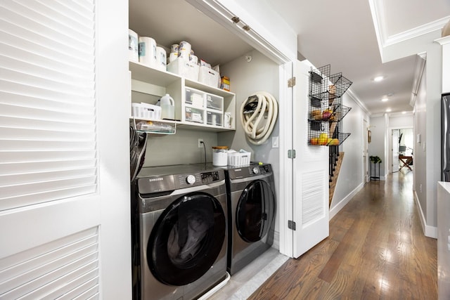 washroom with washing machine and dryer, crown molding, and dark hardwood / wood-style flooring