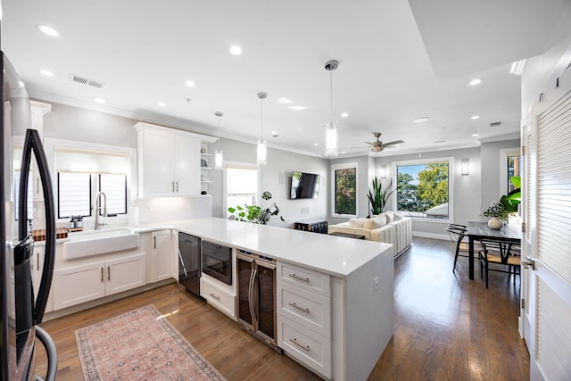 kitchen featuring white cabinets, kitchen peninsula, dark wood-type flooring, and sink