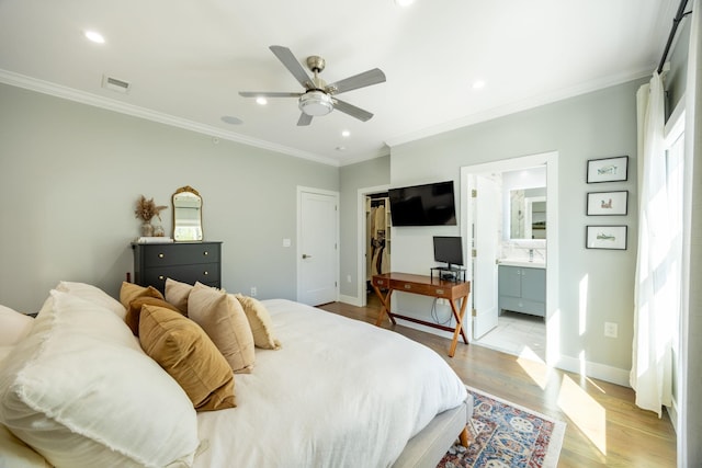 bedroom with a closet, ornamental molding, ensuite bath, light wood-type flooring, and ceiling fan