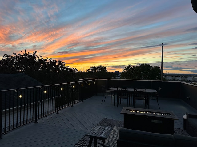 deck at dusk featuring a fire pit