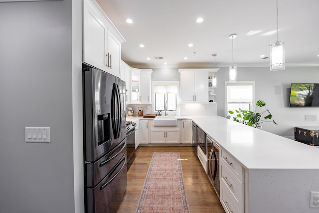 kitchen featuring stainless steel appliances, white cabinetry, tasteful backsplash, hanging light fixtures, and dark hardwood / wood-style flooring