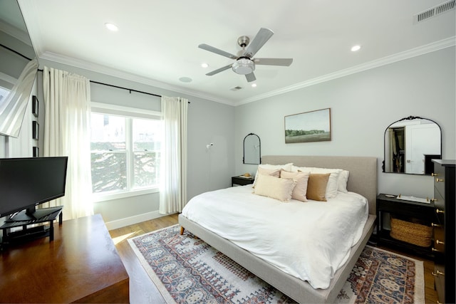 bedroom with crown molding, hardwood / wood-style flooring, and ceiling fan