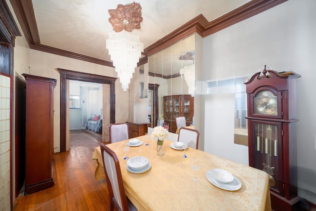 dining space featuring crown molding, a chandelier, and wood-type flooring