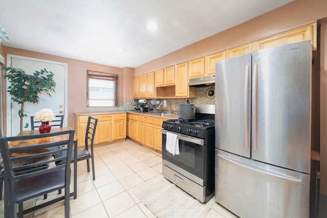 kitchen featuring stainless steel appliances, light brown cabinetry, backsplash, light countertops, and under cabinet range hood